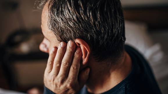 Man with hearing loss and hand to ear