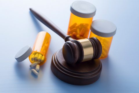 Bottles of medicine with a judge's gavel