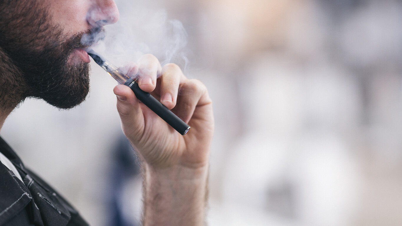Man vaping from an e-cigarette device
