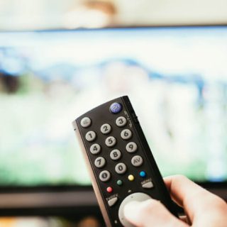 Hand pointing remote towards tv