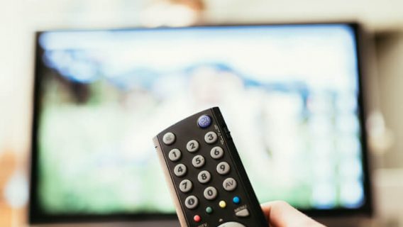 Hand pointing remote towards tv
