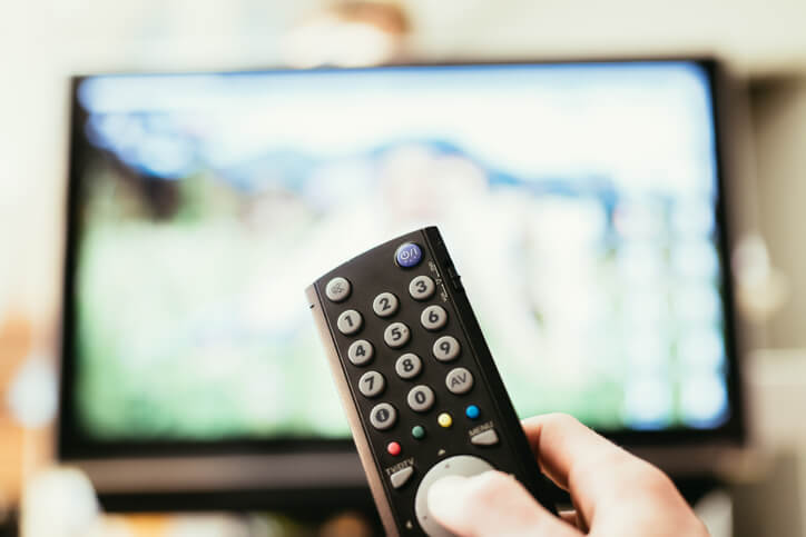 Hand pointing remote towards tv