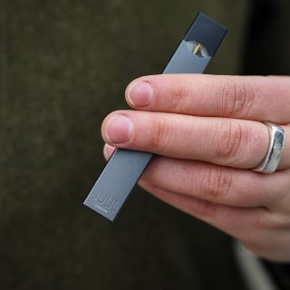 Hand holding a JUUL e-cigarette