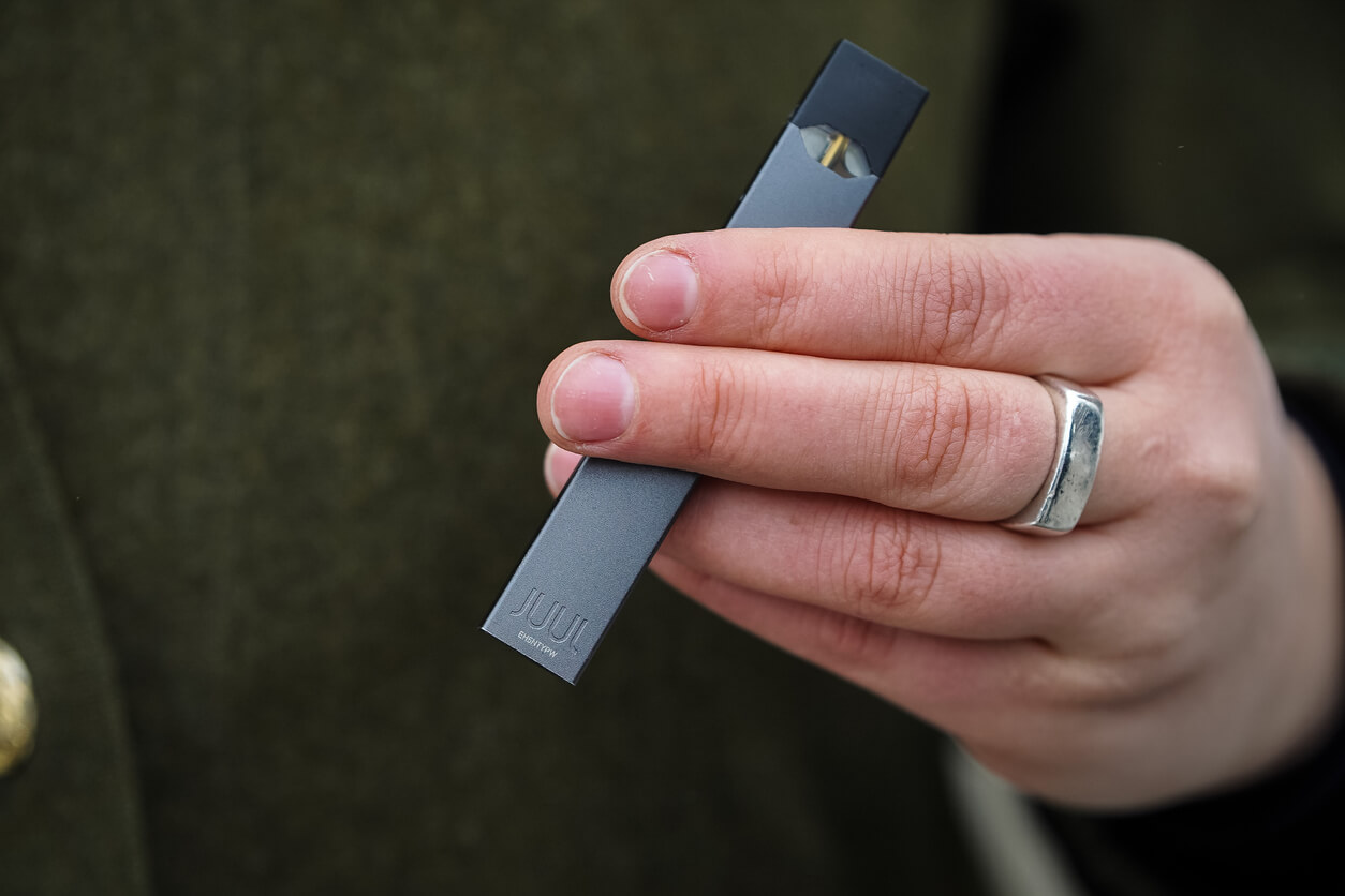 Hand holding a JUUL e-cigarette