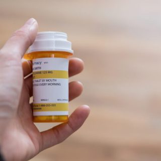 Person holding pill bottle