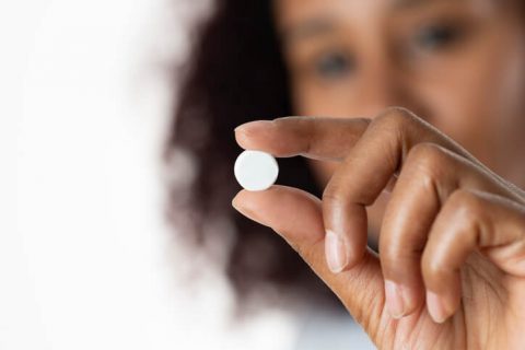 Woman holding birth control pill