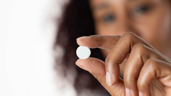Woman holding birth control pill