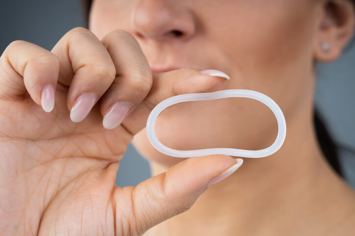 Woman holding plastic ring birth control