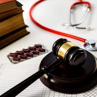 Judge gavel with pills and stethoscope