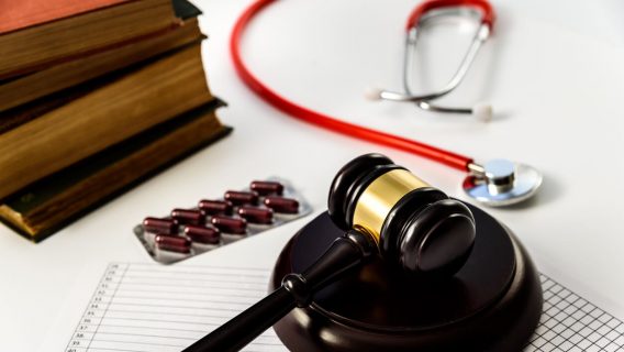 Judge gavel with pills and stethoscope