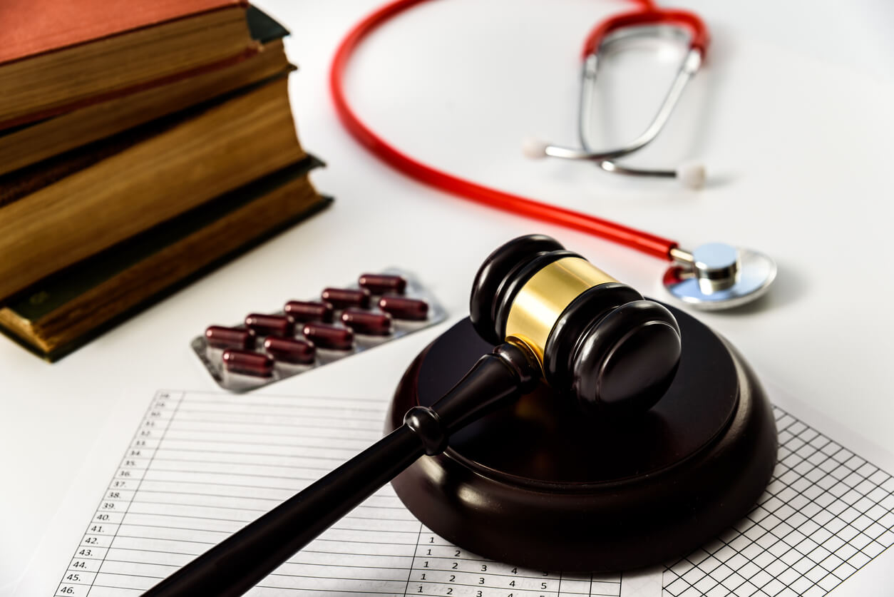 Judge gavel with pills and stethoscope