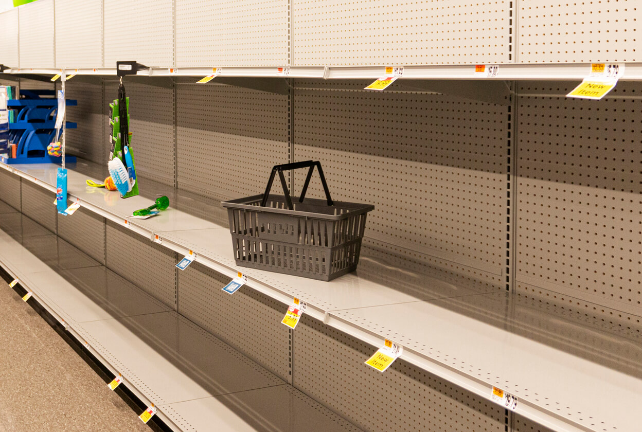 an empty shopping basket sits on an empty shelf at the grocery store