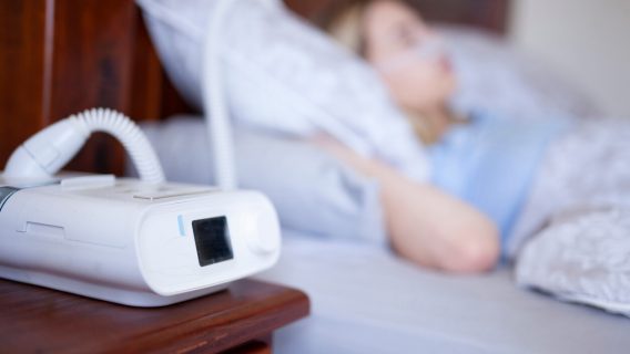 Woman sleeping and using a CPAP machine