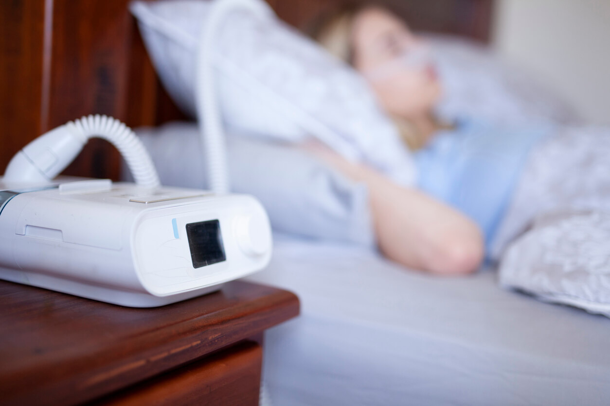Woman sleeping and using a CPAP machine