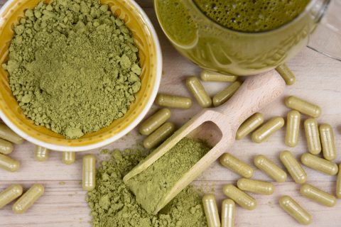kratom capsules and powder on a table