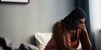 A woman places her head in her hand after undergoing pain, possibly because of of a Depo-Provera-related meningioma diagnosis.