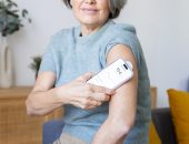 Woman tracking blood sugar using a glucose monitor and smartphone