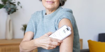 Woman tracking blood sugar using a glucose monitor and smartphone