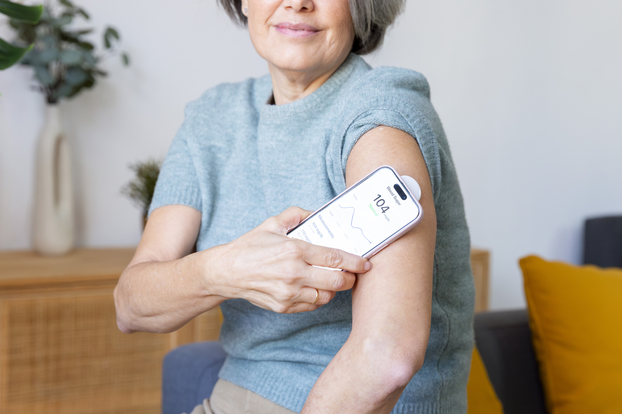 Woman tracking blood sugar using a glucose monitor and smartphone