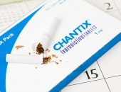 Broken cigarette on top of a pack of Chantix pills