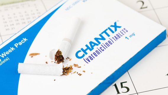 Broken cigarette on top of a pack of Chantix pills