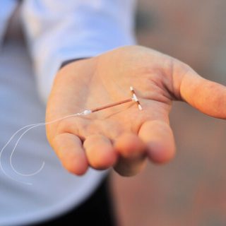 Person holding IUD in their hand
