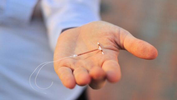 Person holding IUD in their hand