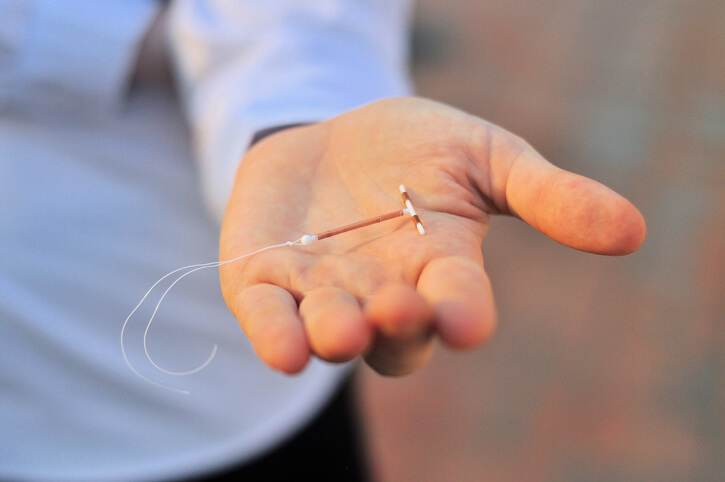 Person holding IUD in their hand
