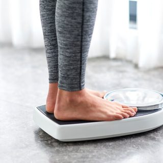 Person weighing themselves on a scale