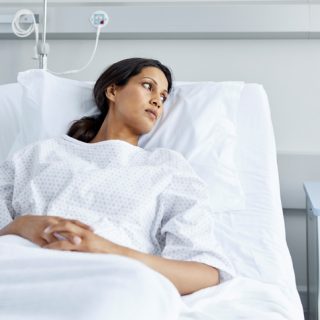 Woman in hospital bed wearing gown