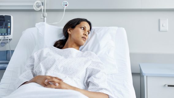 Woman in hospital bed wearing gown