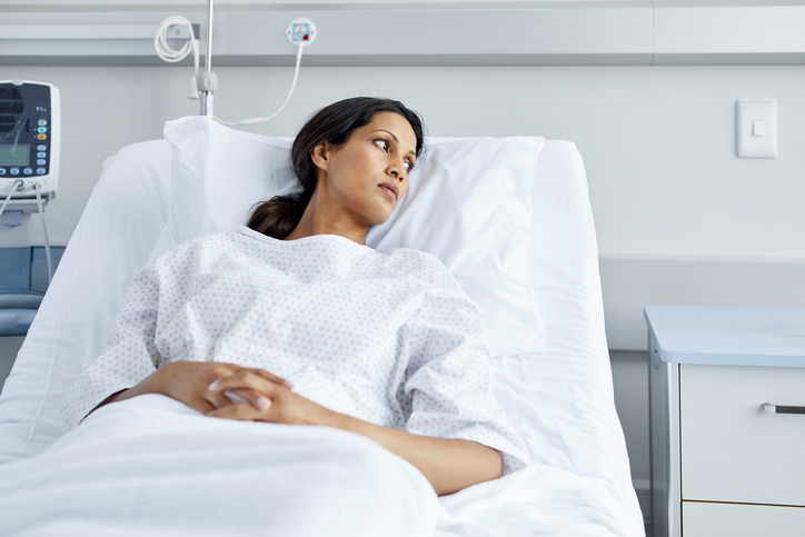 Woman in hospital bed wearing gown