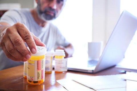 Man looking at a pill bottle