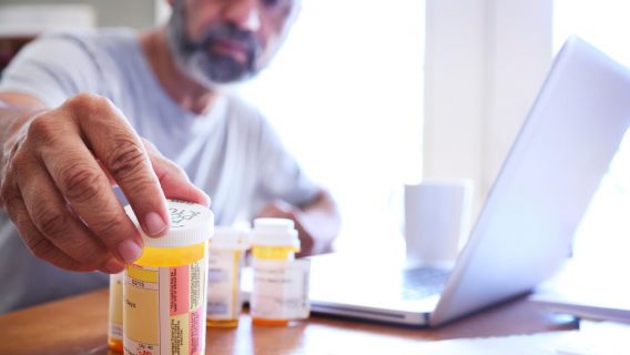 Man looking at a pill bottle