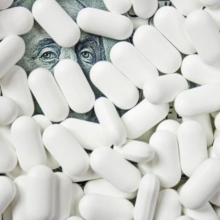 Pharmaceutical pills atop money