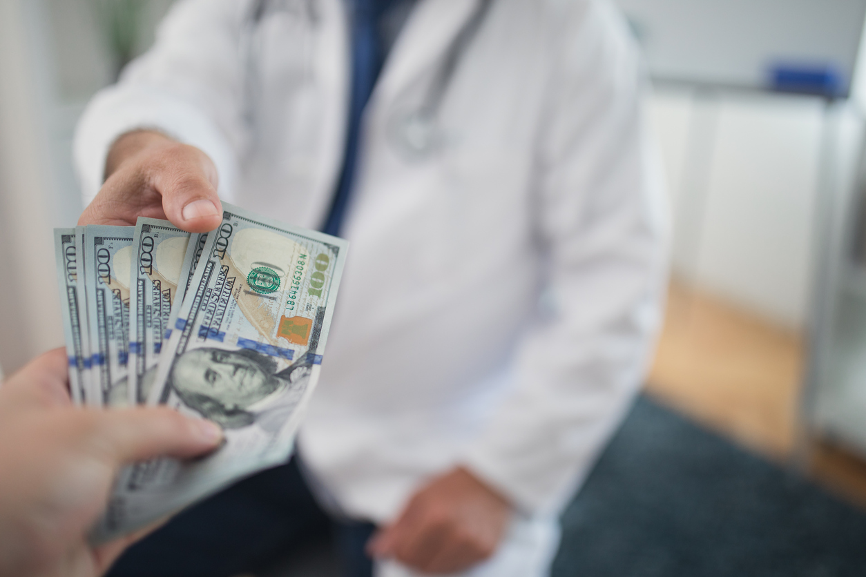 Doctor receiving cash from individual