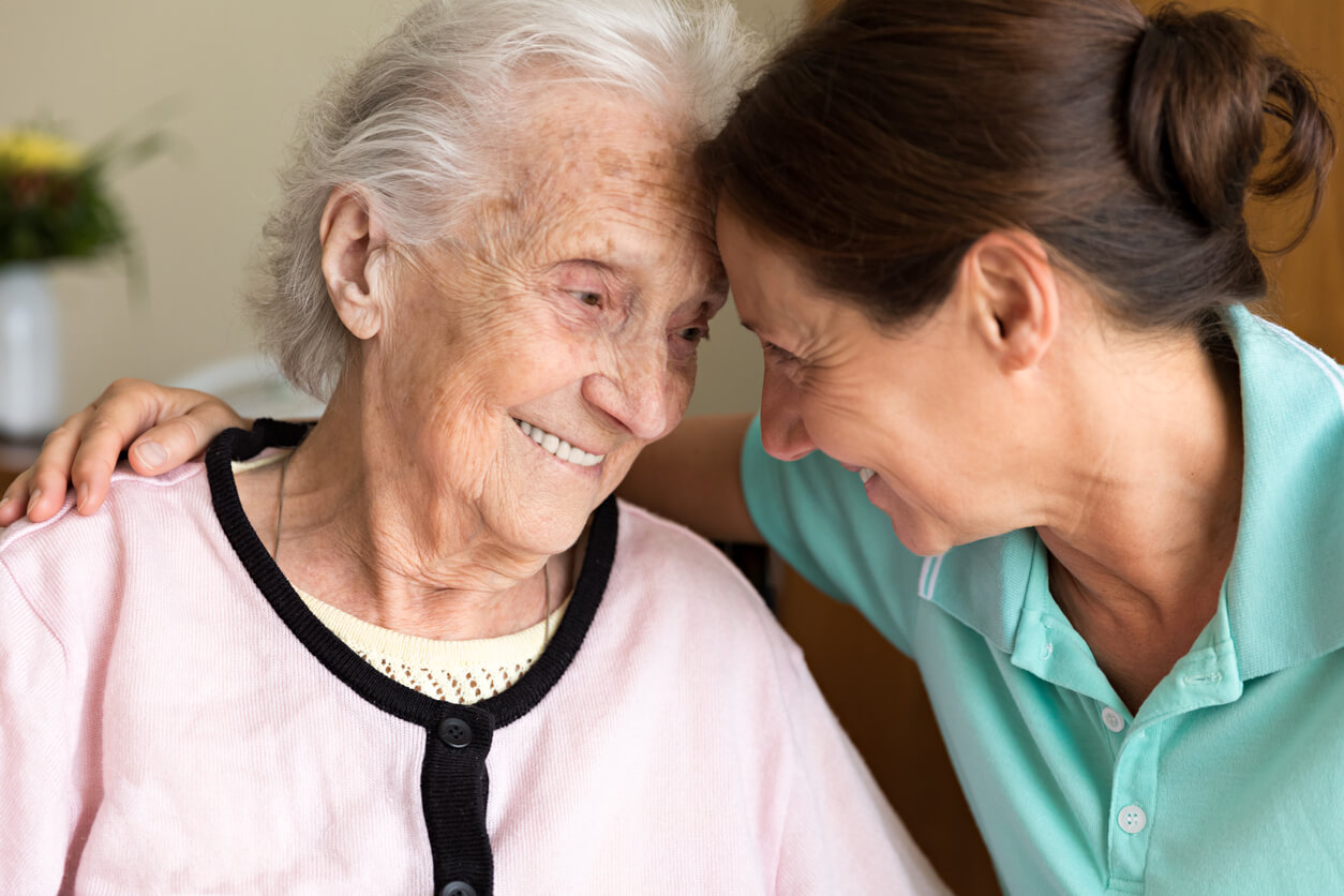 Caregiver and senior woman embracing