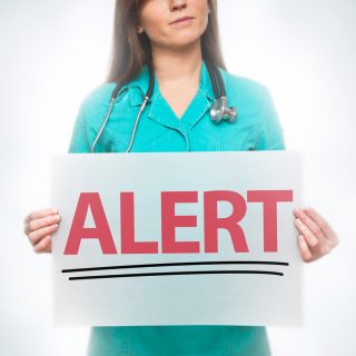 doctor holding alert sign