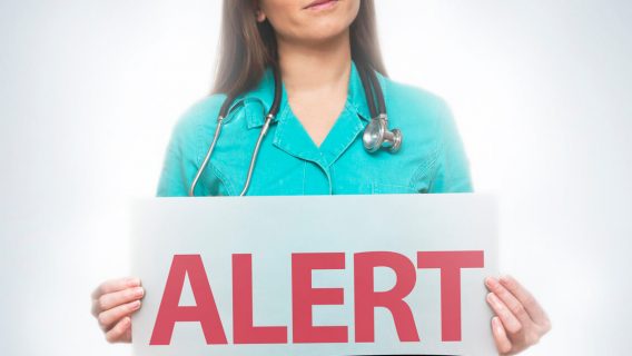 doctor holding alert sign