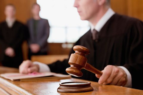 Judge holding gavel in court room