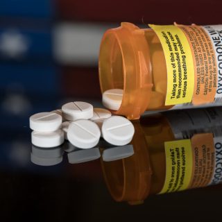 Oxycodone pills with American flag in background