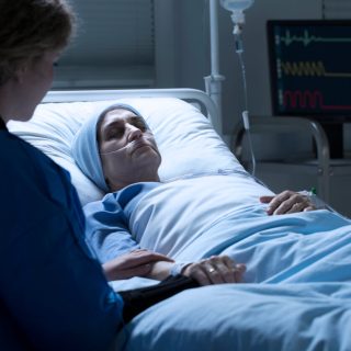 woman in coma with relative by her side