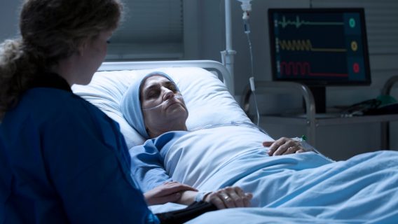 woman in coma with relative by her side