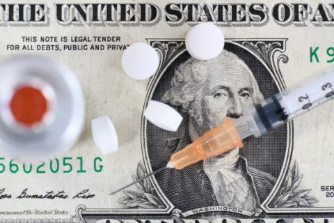 Syringe and pills on dollar bill