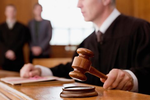 Judge in courtroom holding gavel