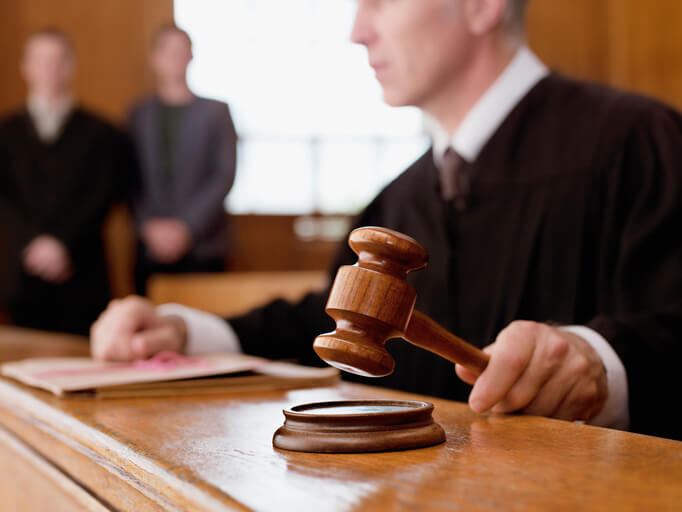 Judge in courtroom holding gavel