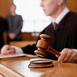 Judge holding gavel in courtroom