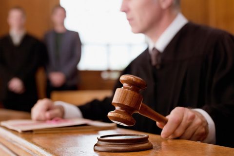 Judge holding gavel in courtroom