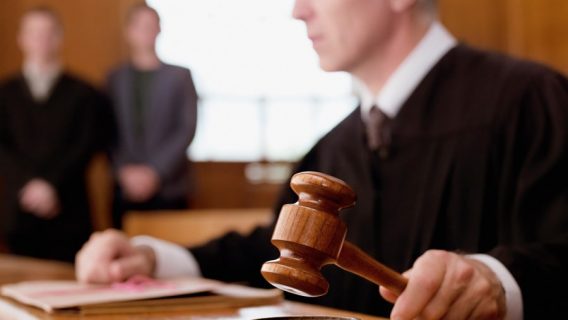 Judge holding gavel in courtroom