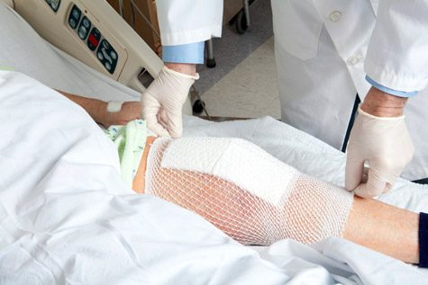 Doctor placing bandage over knee